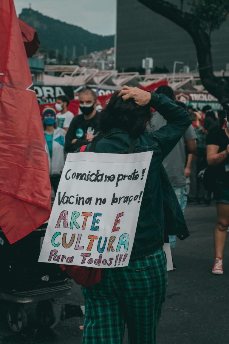 Street protest in Rio de Janeiro promoting art, culture, and vaccination with handwritten signs.
